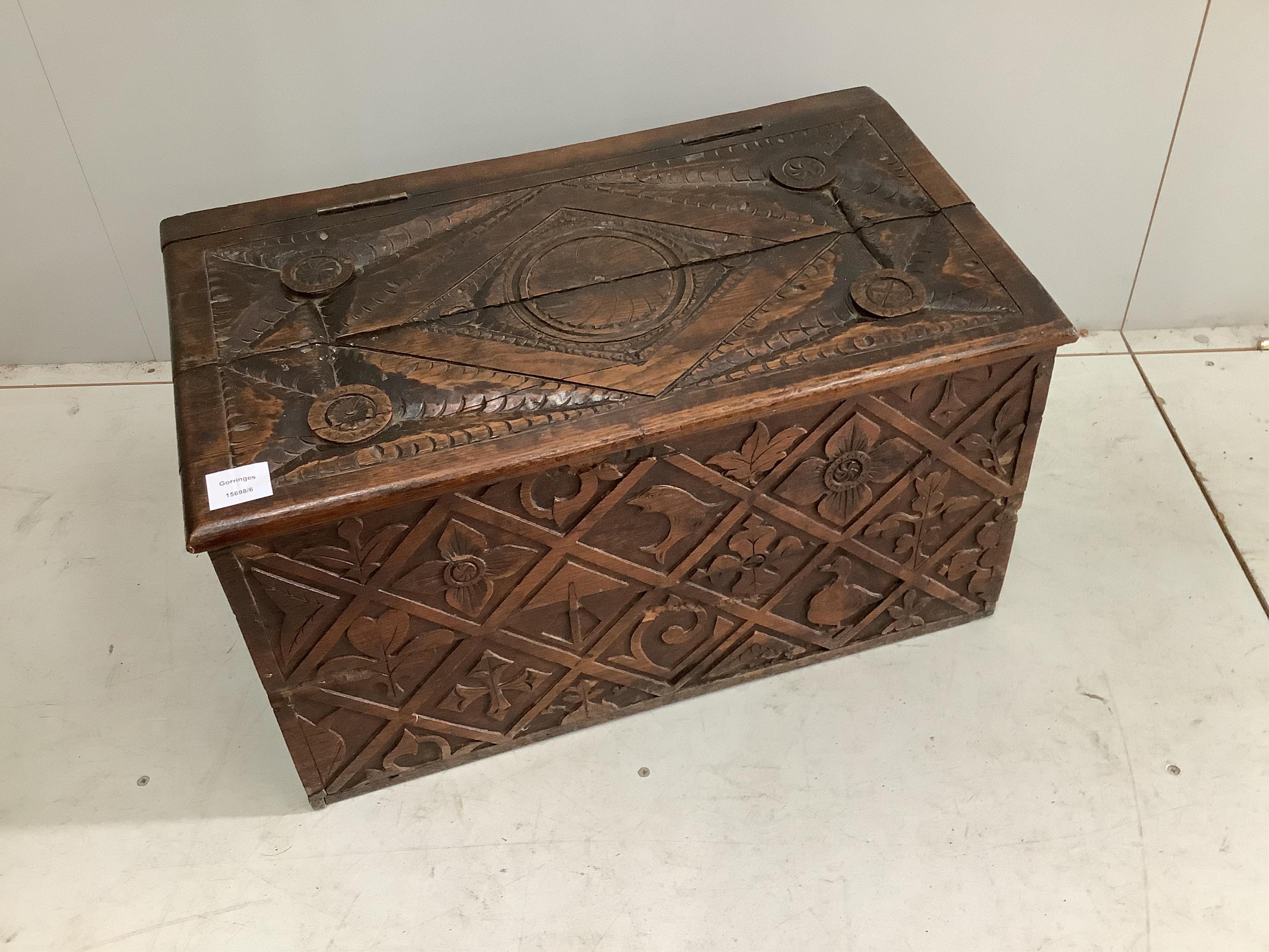 An early 20th century carved oak log bin, width 66cm, height 38cm. Condition - fair